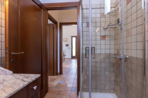 a bathroom with a shower with a glass door at Casa Ulmi con piscina in Uggiano la Chiesa