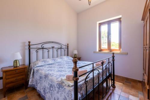a bedroom with a bed and a window at Casa Ulmi con piscina in Uggiano la Chiesa