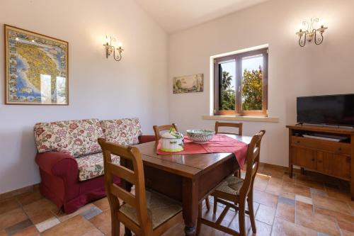 a dining room with a table and a couch at Casa Ulmi con piscina in Uggiano la Chiesa