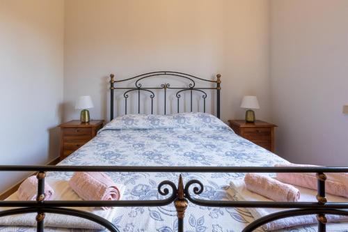 a bedroom with a bed with a blue and white comforter at Casa Ulmi con piscina in Uggiano la Chiesa