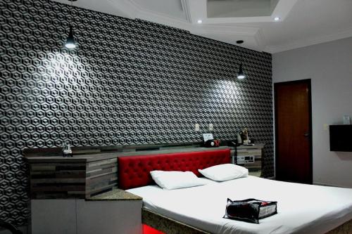 a bedroom with a large bed with a red headboard at MOTEL COPACABANA in Ribeirão Preto