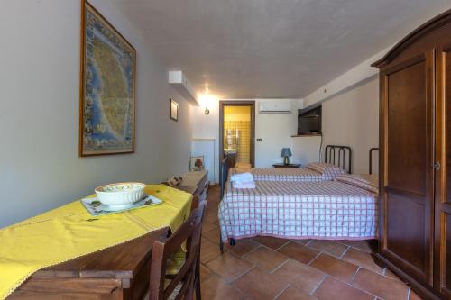 a room with two beds and a table and chairs at Casa Ulmi con piscina in Uggiano la Chiesa