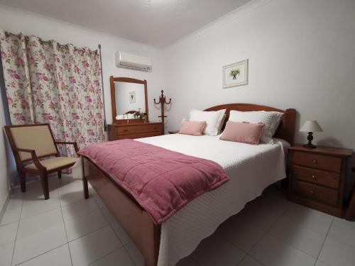 - une chambre avec un grand lit et une chaise dans l'établissement South Beach, à Portimão