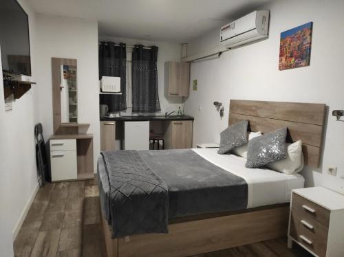 a bedroom with a large bed and a kitchen at hostal olozaga in Alicante