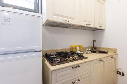 a kitchen with a stove and a refrigerator at Casa Ulmi con piscina in Uggiano la Chiesa