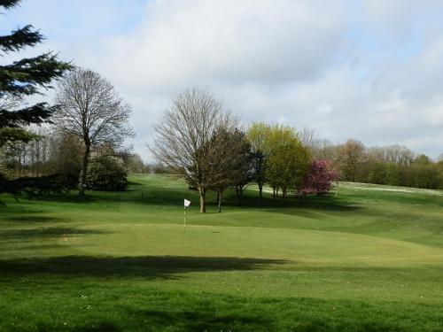 een golfbaan met een gat in het gras bij Les Belleme Golf - Self-catering Apartments in Bellême