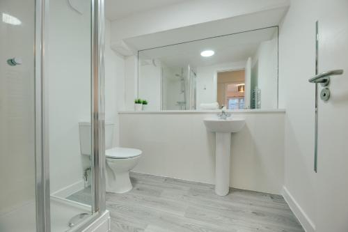 a white bathroom with a toilet and a sink at Charltons Bonds Apartments 18 by Week2Week in Newcastle upon Tyne