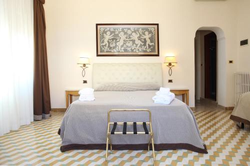 a bedroom with a bed with two towels on it at Albergo Russo in Trapani
