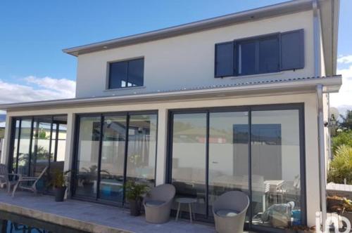 a house with large glass windows and a patio at Villa Mary Guest House in Saint-André