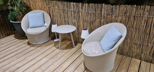 two chairs and a table on a wooden deck at Villa Mary Guest House in Saint-André