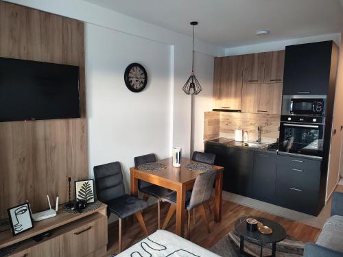 ein Wohnzimmer mit einem Tisch und einer Küche in der Unterkunft NLux46 Milmari in Kopaonik