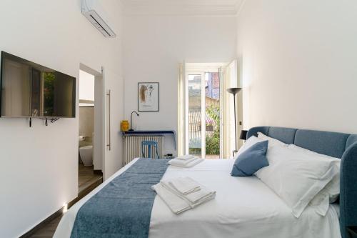 a bedroom with a bed with white and blue pillows at SiSTO18 in Catania