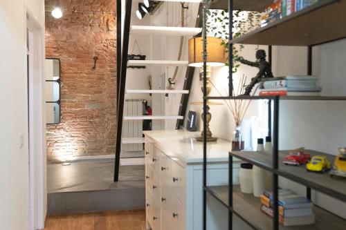 a kitchen with white cabinets and a brick wall at Luxury Apartament Florence in Florence