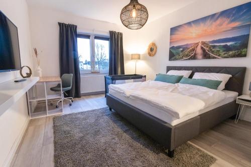 a bedroom with a bed and a desk and a window at Q-FLATS Bochum-Hamme - verkehrsgünstig und komfortabel in Bochum