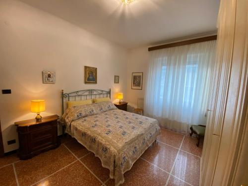 een slaapkamer met een bed, 2 lampen en een raam bij Casa Augusta in Rapallo