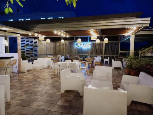 a restaurant with white chairs and tables at night at Hotel Rosales Boutique in Neiva