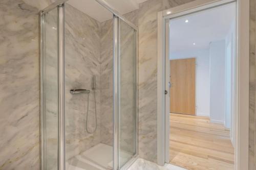 um chuveiro com uma porta de vidro num quarto em Campolide 2 bedroom delight By Innkeeper em Lisboa