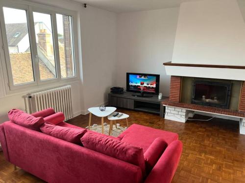 sala de estar con sofá rojo y TV en Le temps du Loing en Nemours