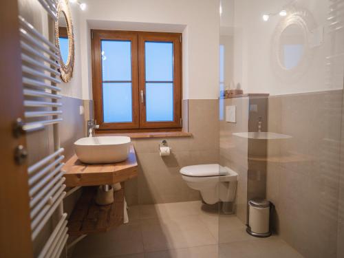 a bathroom with a sink and a toilet and a window at Ferienwohnungen Ebensperger - Chiemgau Karte in Inzell