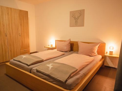 a bedroom with a large bed with two pillows at Ferienwohnungen Ebensperger - Chiemgau Karte in Inzell