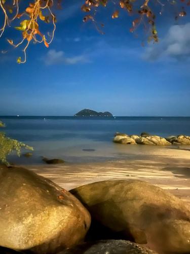 a view of a beach with rocks in the water at Siam Cookies Cottage in Haad Pleayleam