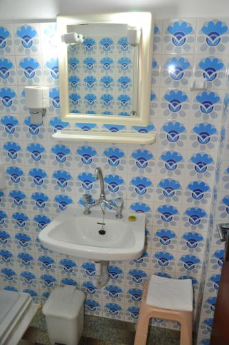 a bathroom with blue and white tiled walls and a sink at Nora Hotel in Sitia
