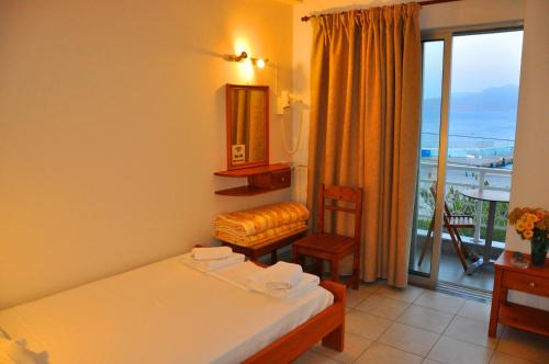 a hotel room with a bed and a balcony at Nora Hotel in Sitia