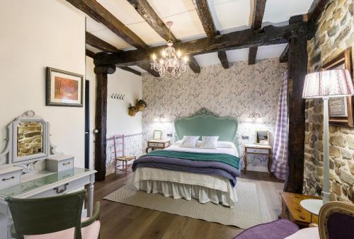 1 dormitorio con cama y pared de piedra en Posada Casa Guadamillas, 