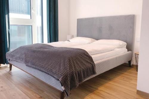 een bed met een deken erop in een slaapkamer bij Laurentia Penthouse-Apartment in Merano