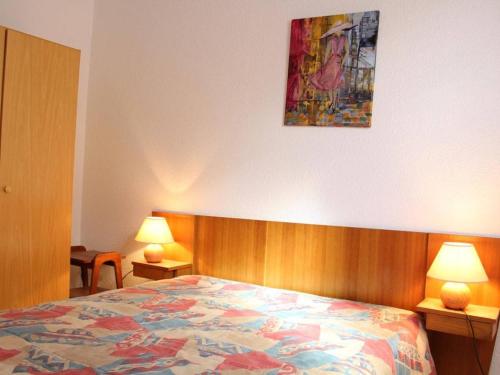 - une chambre avec un lit avec deux lampes et un tableau mural dans l'établissement Maison 2 pièces, cabine, 6 pers, plage à 400m, parking, terrasse - FR-1-229C-187, à Port-la-Nouvelle