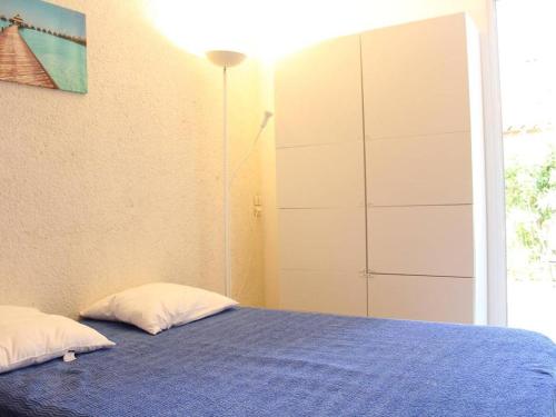 een slaapkamer met een bed en een grote kast bij Maison Port-la-Nouvelle, 3 pièces, 6 personnes - FR-1-229C-7 in Port-la-Nouvelle