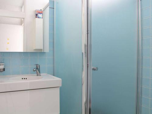 La salle de bains est pourvue d'un lavabo et d'une porte de douche. dans l'établissement Maison traversante climatisée, 200m de la plage, 2 terrasses, 2 chambres, 6 couchages - FR-1-229C-7, à Port-la-Nouvelle