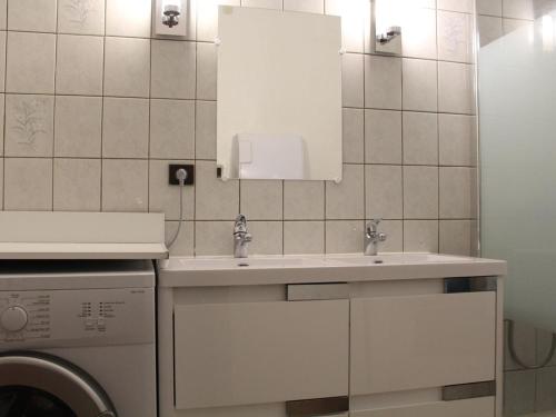 une salle de bain avec un lavabo et une machine à laver dans l'établissement Appt 3 pièces 6 personnes avec parking, à 300m des commerces - FR-1-229C-49, à Port-la-Nouvelle