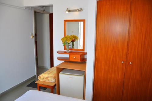 a bedroom with a table with a mirror and a cabinet at Nora Hotel in Sitia