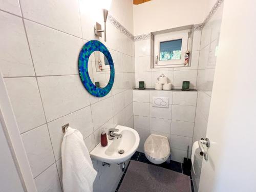 a white bathroom with a sink and a mirror at Sunny Mountain Loft - Terrace & Garden in Thaur