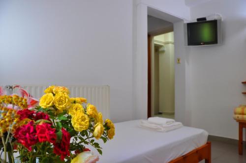 a room with a bed with a bouquet of flowers at Nora Hotel in Sitia