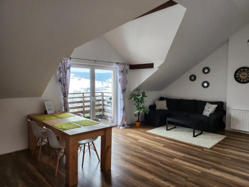 a living room with a table and a couch at Apartament u Ewki in Rdzawka