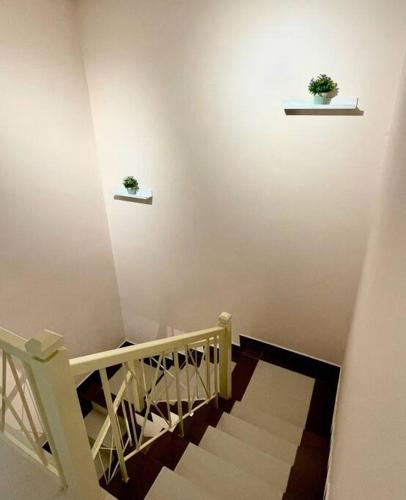 a staircase with two potted plants on the wall at 6-12pax The Premium House - The Heart Of Sunway in Petaling Jaya