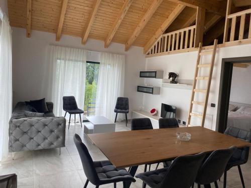 - un salon avec une table et des chaises en bois dans l'établissement Cabanele Olena, à Borsa