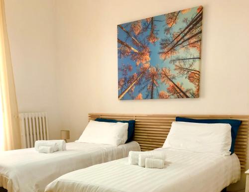 two beds in a room with a painting on the wall at Casa Lamar in Salerno