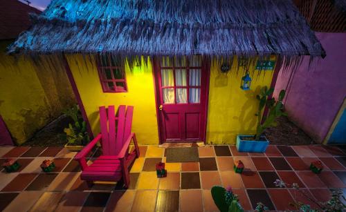 a house with two chairs and a red door at Dunas Tatacoa in Villavieja