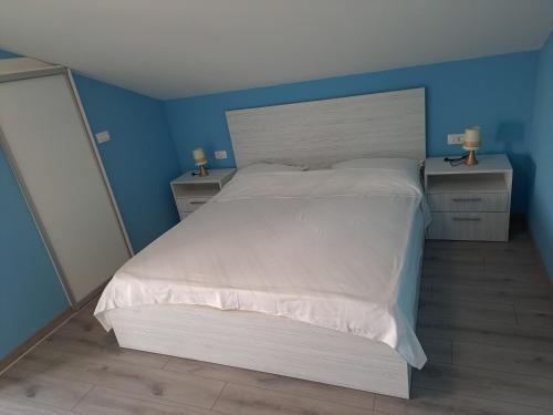 a bedroom with a large white bed with two night stands at Apartman Vidas in Rab