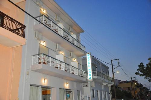 a white building with a sign on the side of it at Nora Hotel in Sitia