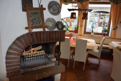 a living room with a brick fireplace and a table at Hotel Löwen in Reit im Winkl