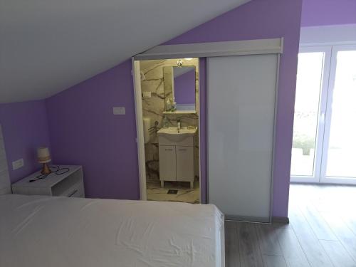 a bedroom with a king sized bed and a mirror at Apartman Vidas in Rab