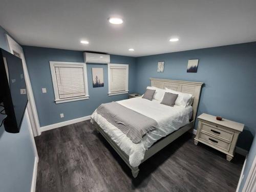 利斯堡的住宿－Paradise on Lake Harris Apt #102，卧室拥有蓝色的墙壁,配有一张床和床头柜。