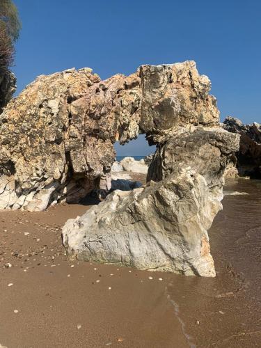 a large rock on the beach with the water at Villa Delfini in Chrani
