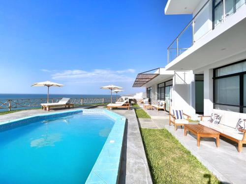 ein Haus mit einem Pool am Meer in der Unterkunft VISTA LINDA BUNGALOW para 4 personas Punta Veleros in Los Órganos