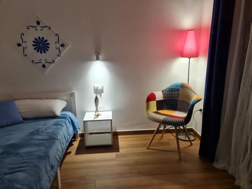 a bedroom with a bed and a chair and a table at Appartamenti MiNuMa Tropea in Tropea