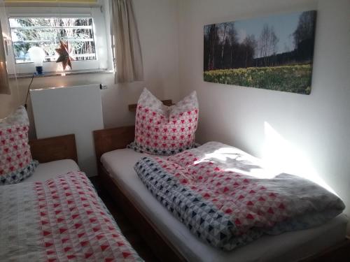 a bedroom with two beds with red and white pillows at Perlenbachtal in Monschau